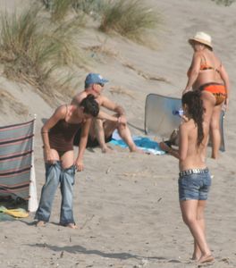 Topless girl goes full-nudist at textile beach  Almeria (Spain)-b6w4xut51c.jpg